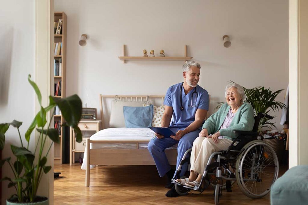 A small group of older adults enjoying a chair yoga session in a sunny common room.